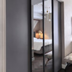 Bespoke Italian fitted wardrobe featuring matte grey lacquer panels and full-height mirrored sliding doors in a luxury bedroom