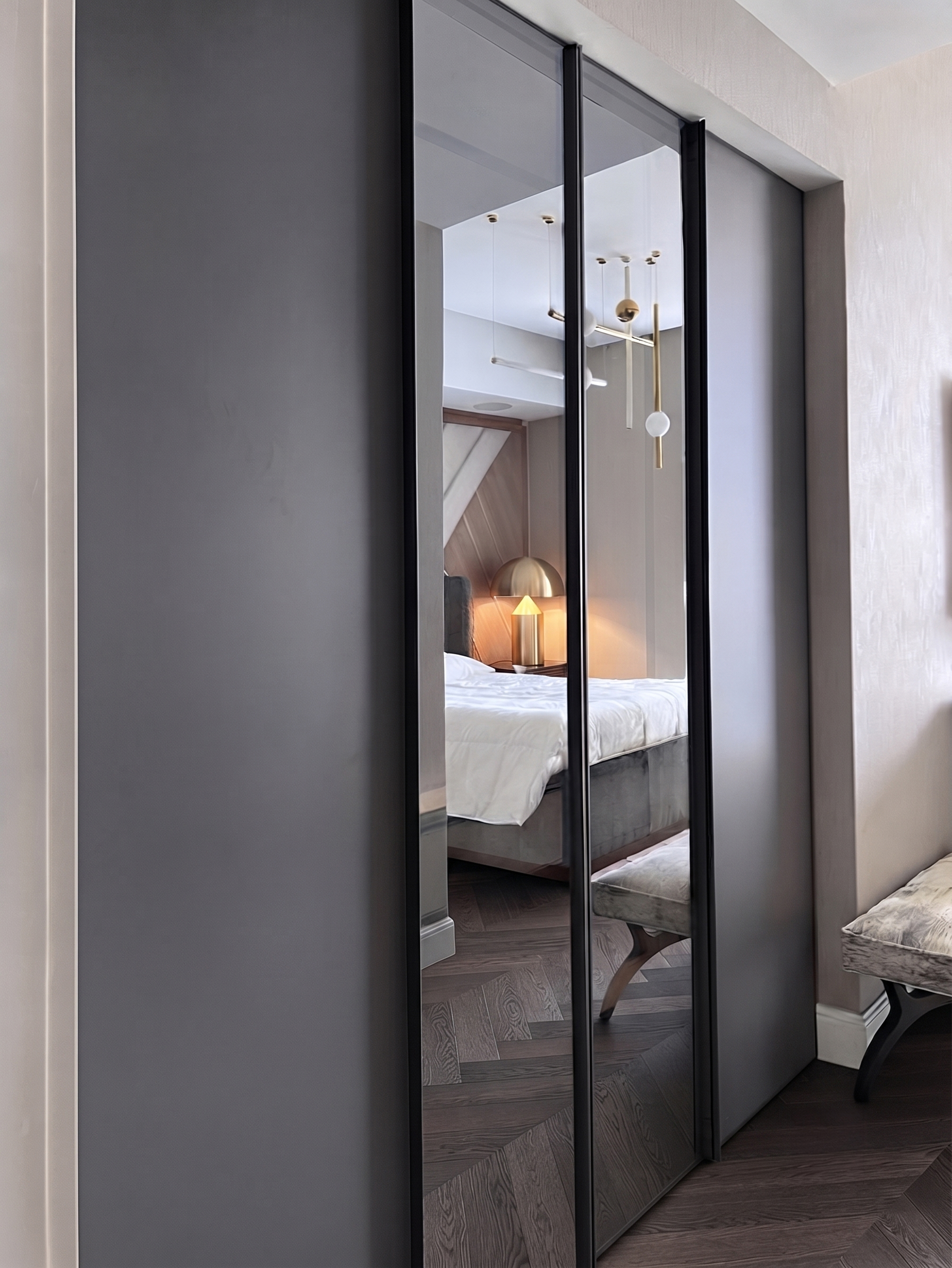 Bespoke Italian fitted wardrobe featuring matte grey lacquer panels and full-height mirrored sliding doors in a luxury bedroom