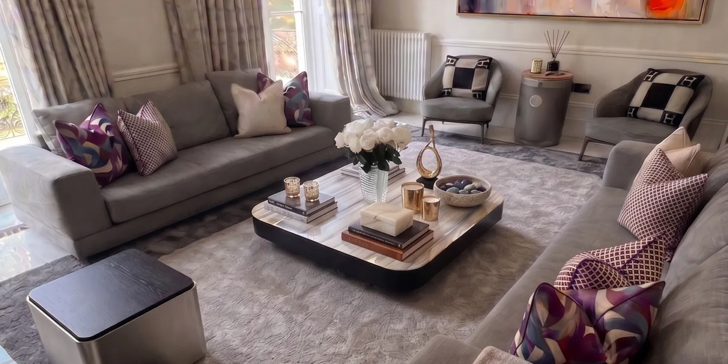 Full view of grand South Kensington drawing room with bespoke grey sofas, large abstract wall art, crystal drum chandelier, and marble border flooring