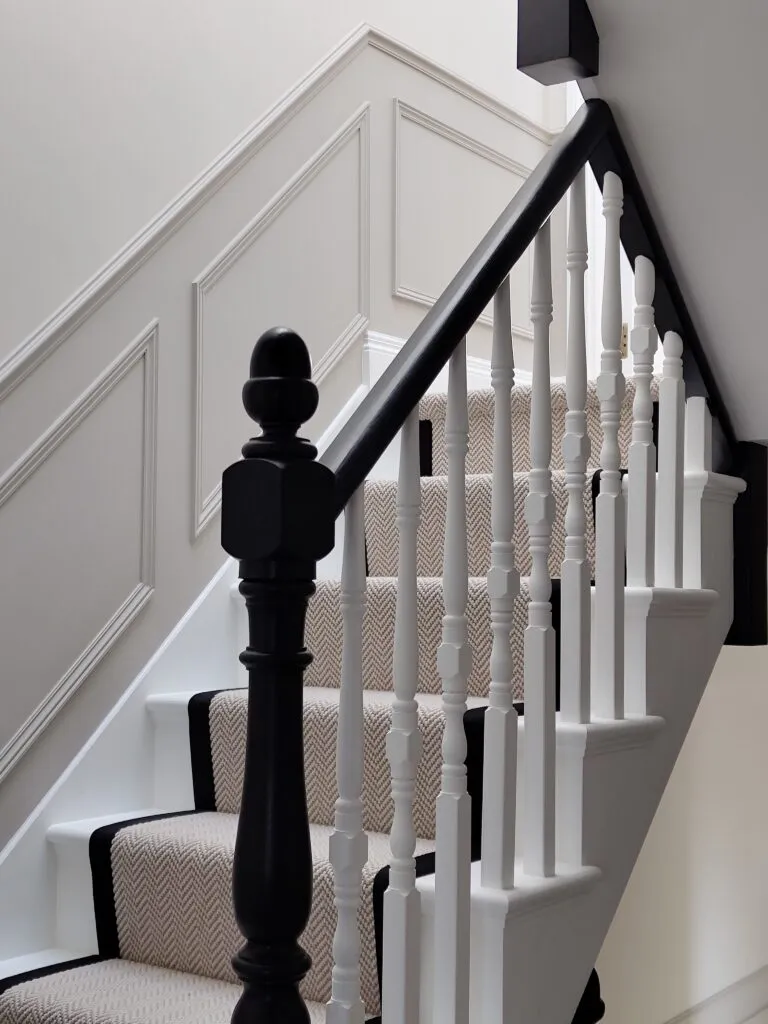 Bespoke Victorian staircase renovation in West Hampstead featuring geometric wall panelling, black painted handrail, and textured runner by Paolo Rota Interiors