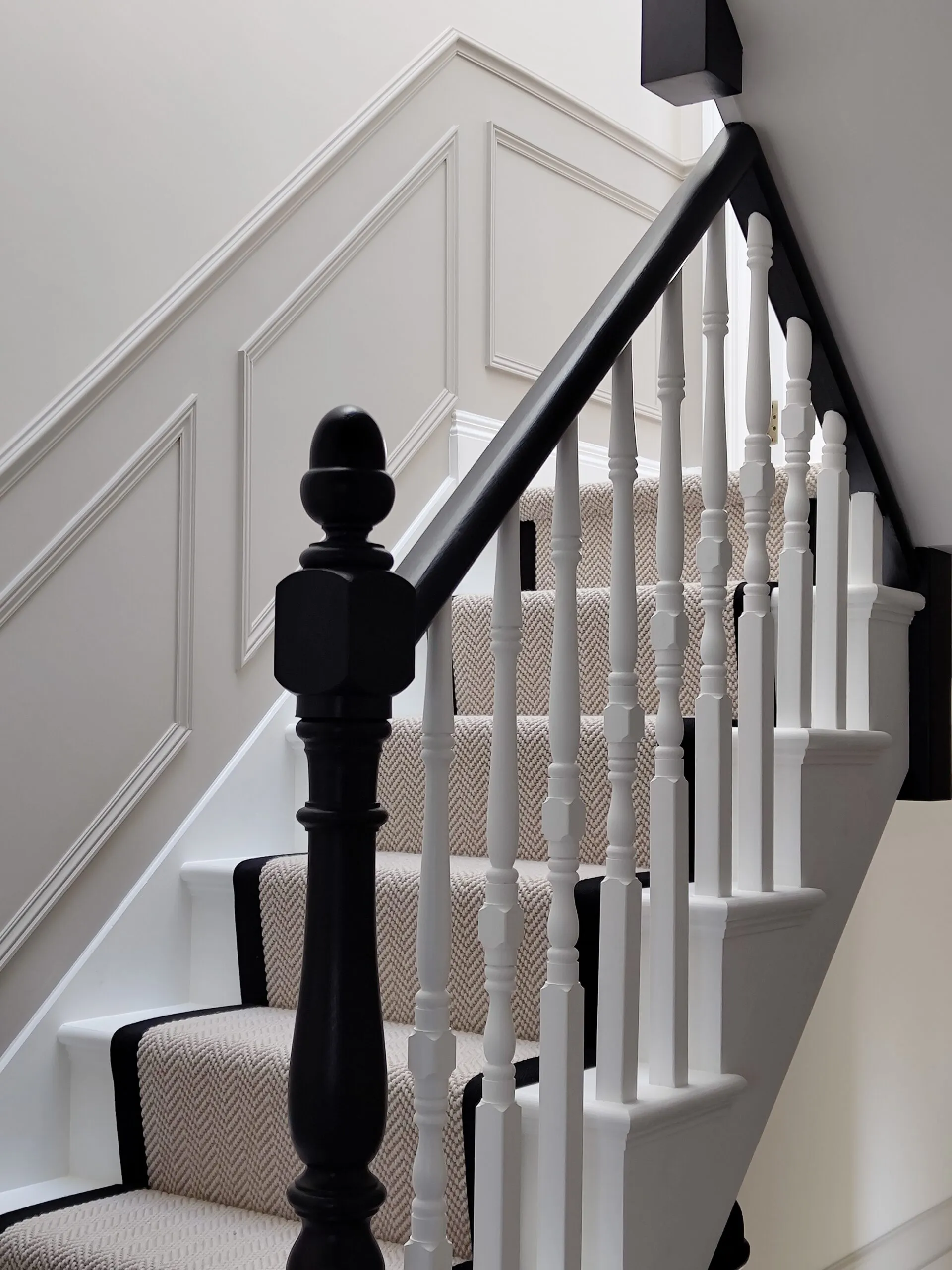 Bespoke Victorian staircase renovation in West Hampstead featuring geometric wall panelling, black painted handrail, and textured runner by Paolo Rota Interiors