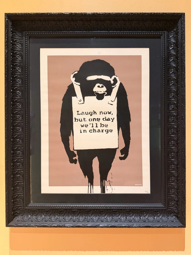 Framed Banksy Laugh Now screen-print displayed in a luxury interior design project