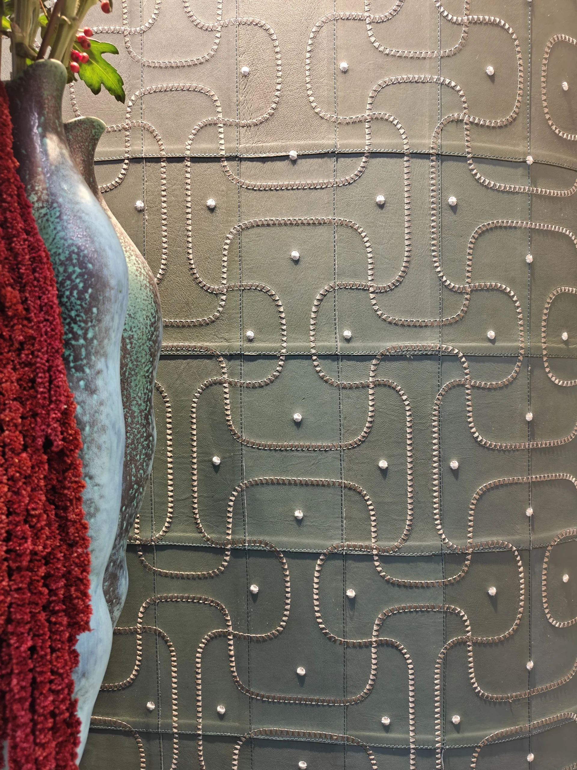 Bespoke stitched sage green leather wallcovering panel with geometric embroidery detail at Decorex London