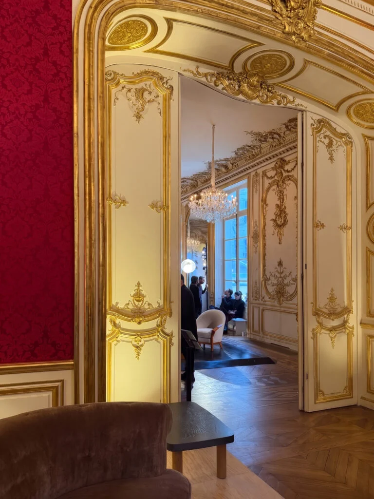 Historic 18th-century gilded salon and crystal chandelier framing collectible lounge seating at Design Miami Paris in L'Hotel de Maisons