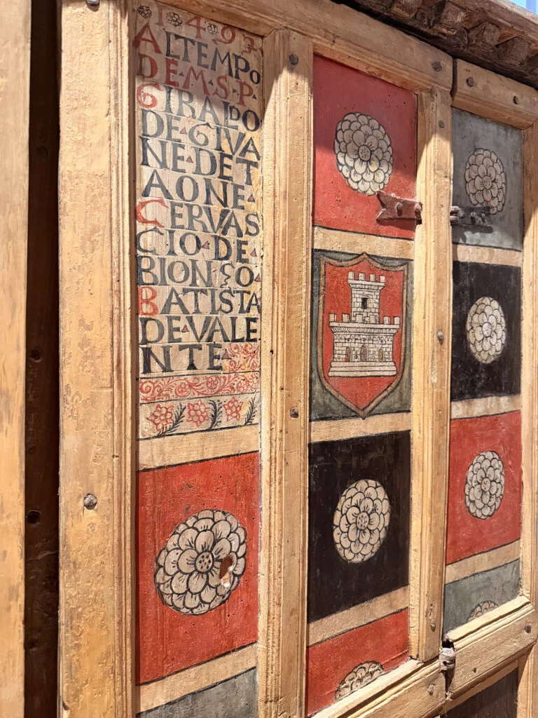 Historic painted wood panels and crests on wardrobe doors in Gubbio, inspiring bespoke interior design in London