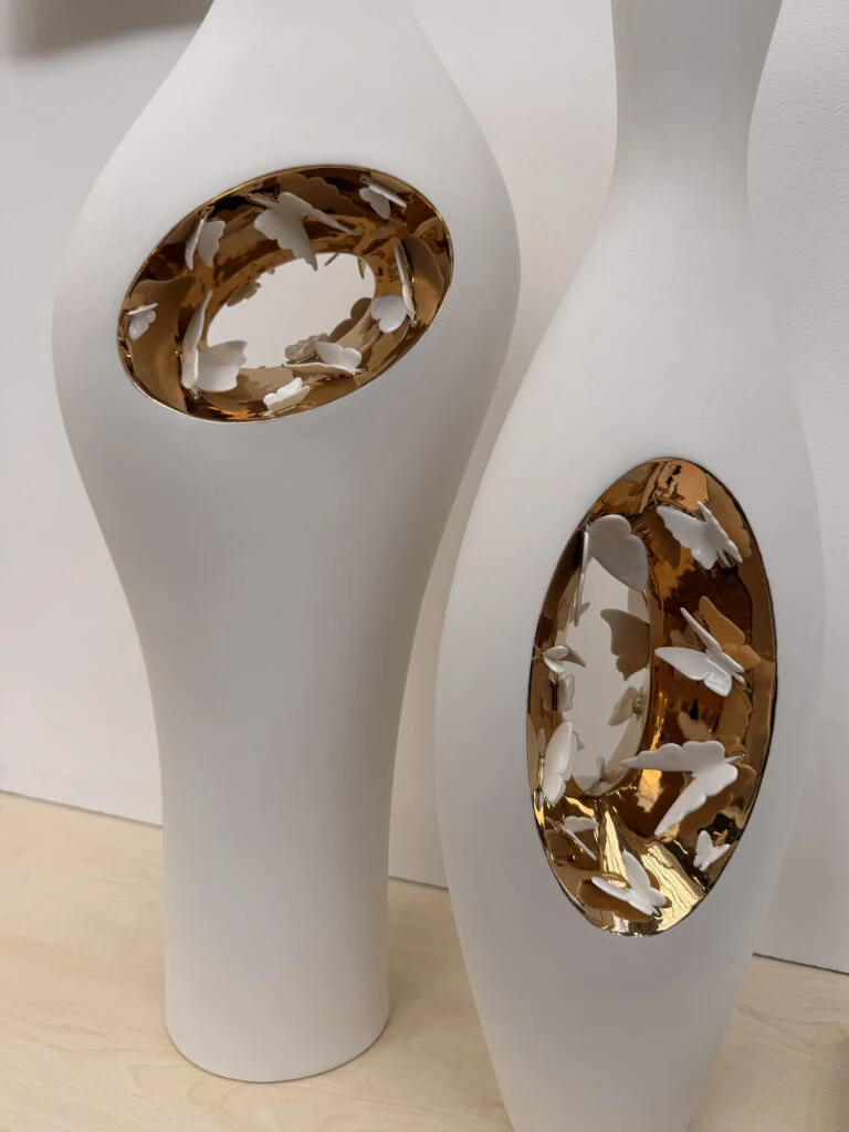 Sculptural white ceramic floor vases with gold leaf interior apertures and delicate porcelain butterflies at Decorex London