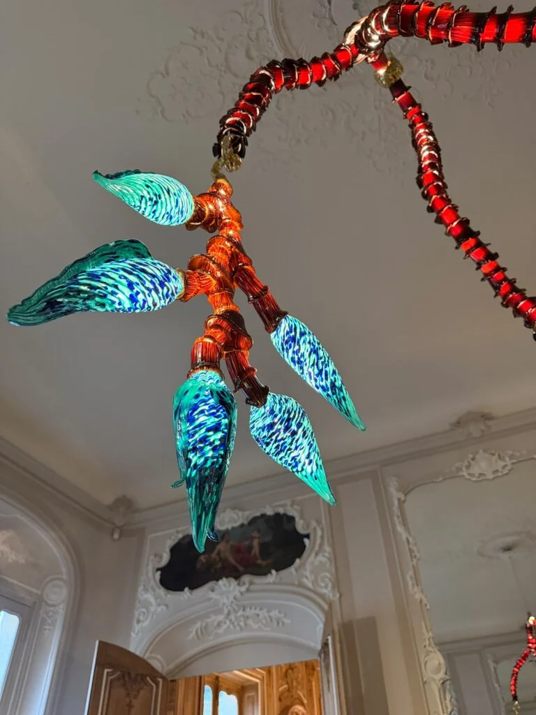 Hand-blown Venetian glass botanical chandelier featuring ribbed amber armature and vivid cyan striped floral glass diffusers